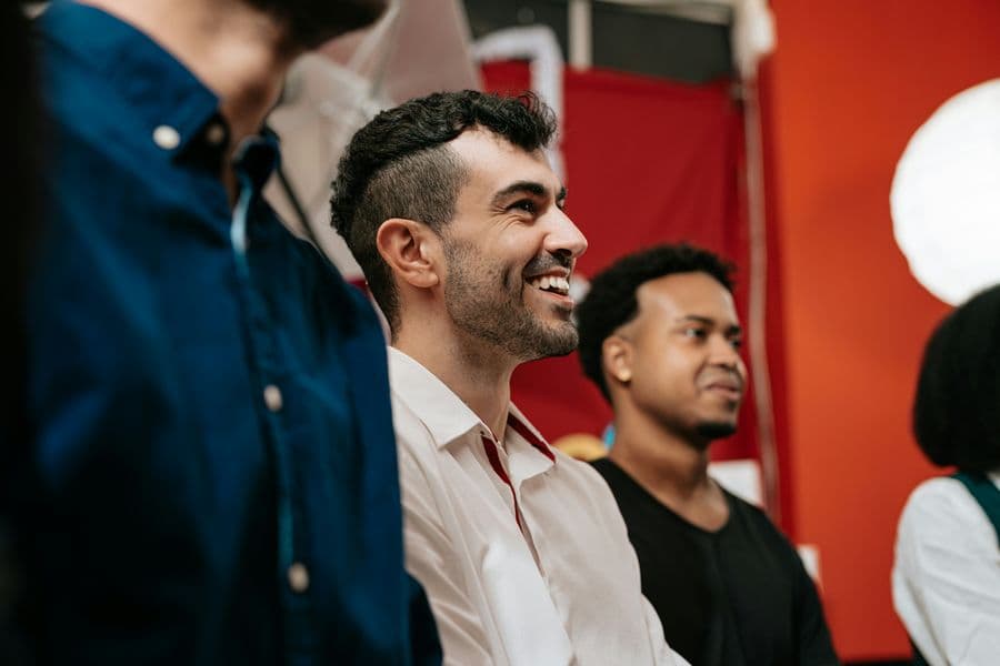 Men in a group therapy session, laughing and connecting during recovery